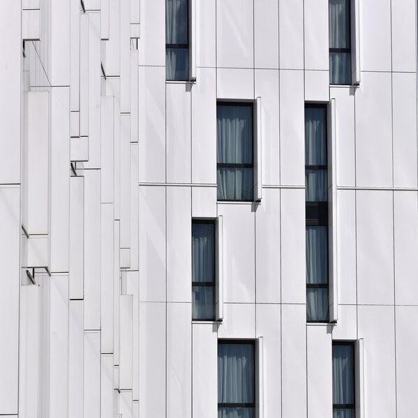 Habillage de façade avec des panneaux blancs et des vitres.