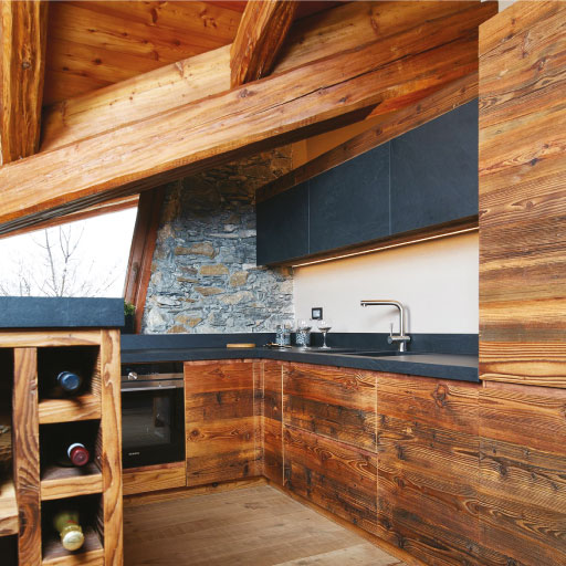 Photo d'ambiance dans une cuisine en bois, avec un plan de travail et des rangements de couleur noir