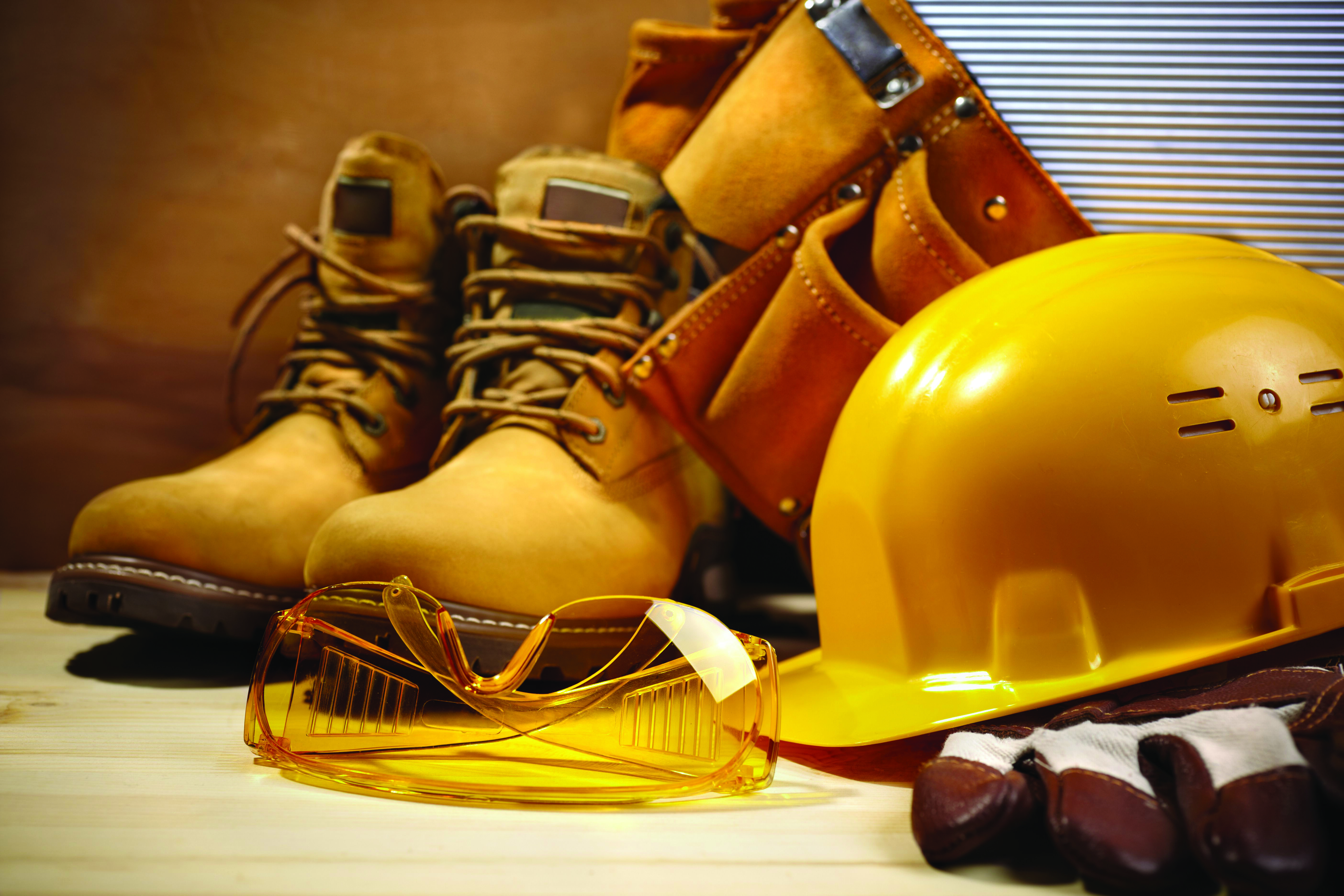 Habillements de chantier avec un casque jaune, des lunettes de protection, des chaussures et une paire de gants.